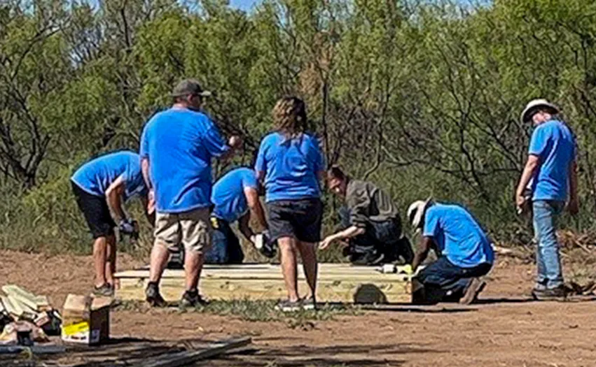 A group of 7 volunteers building something out of wood (Photo)