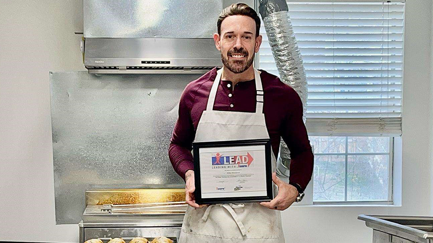 A man holding the icare award